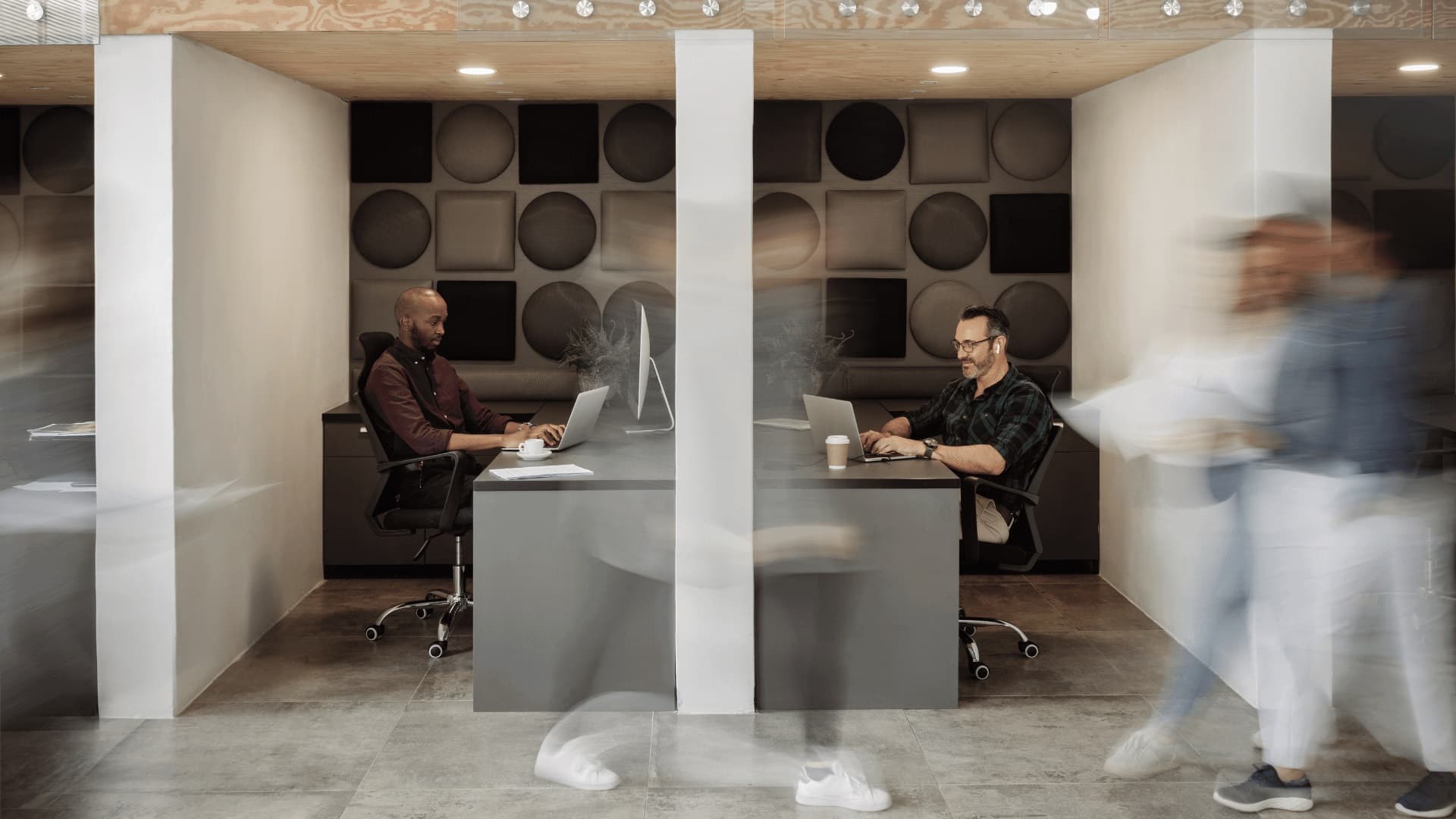 کارکنان مرد در حال کار با لپ تاپ در دفتر مدرن 