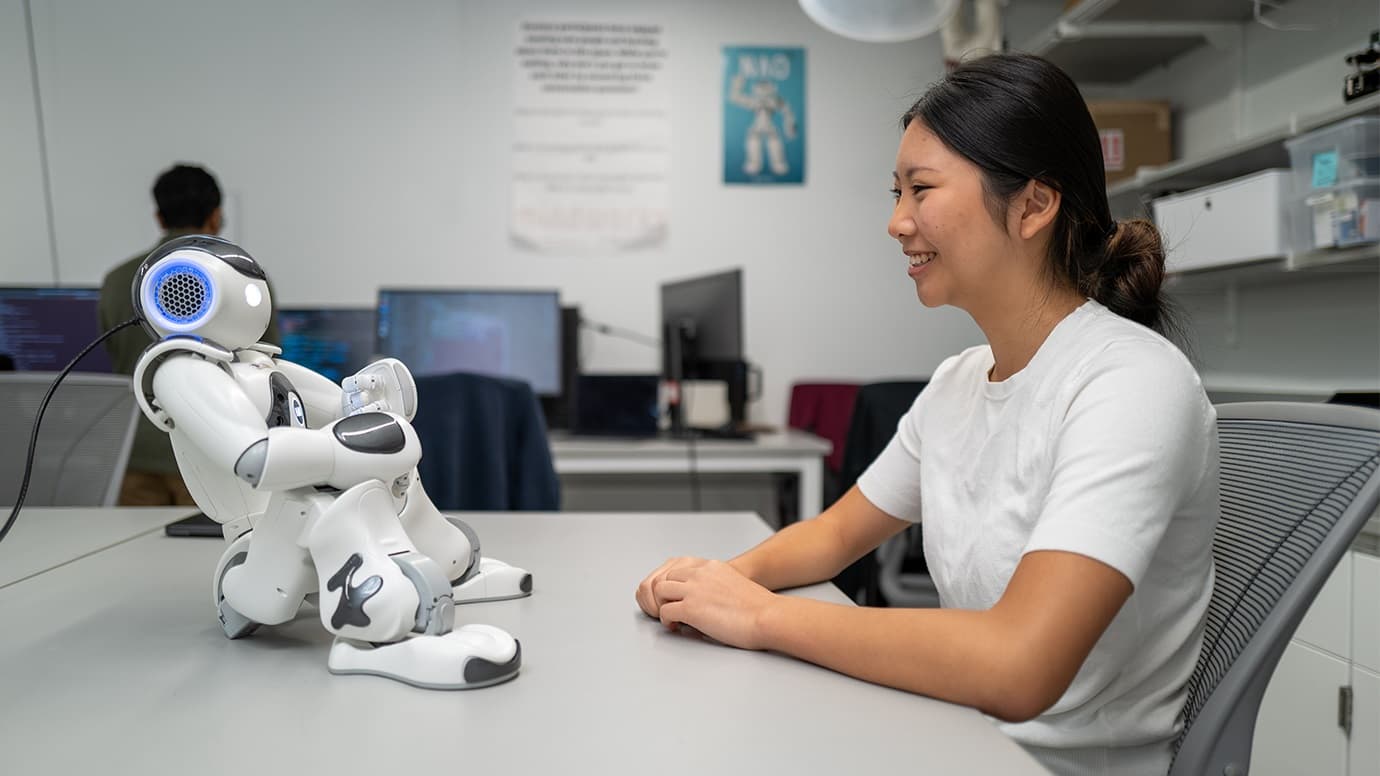 ربات انسان‌نمای کوچک روی میز مدیر در دفتر کار